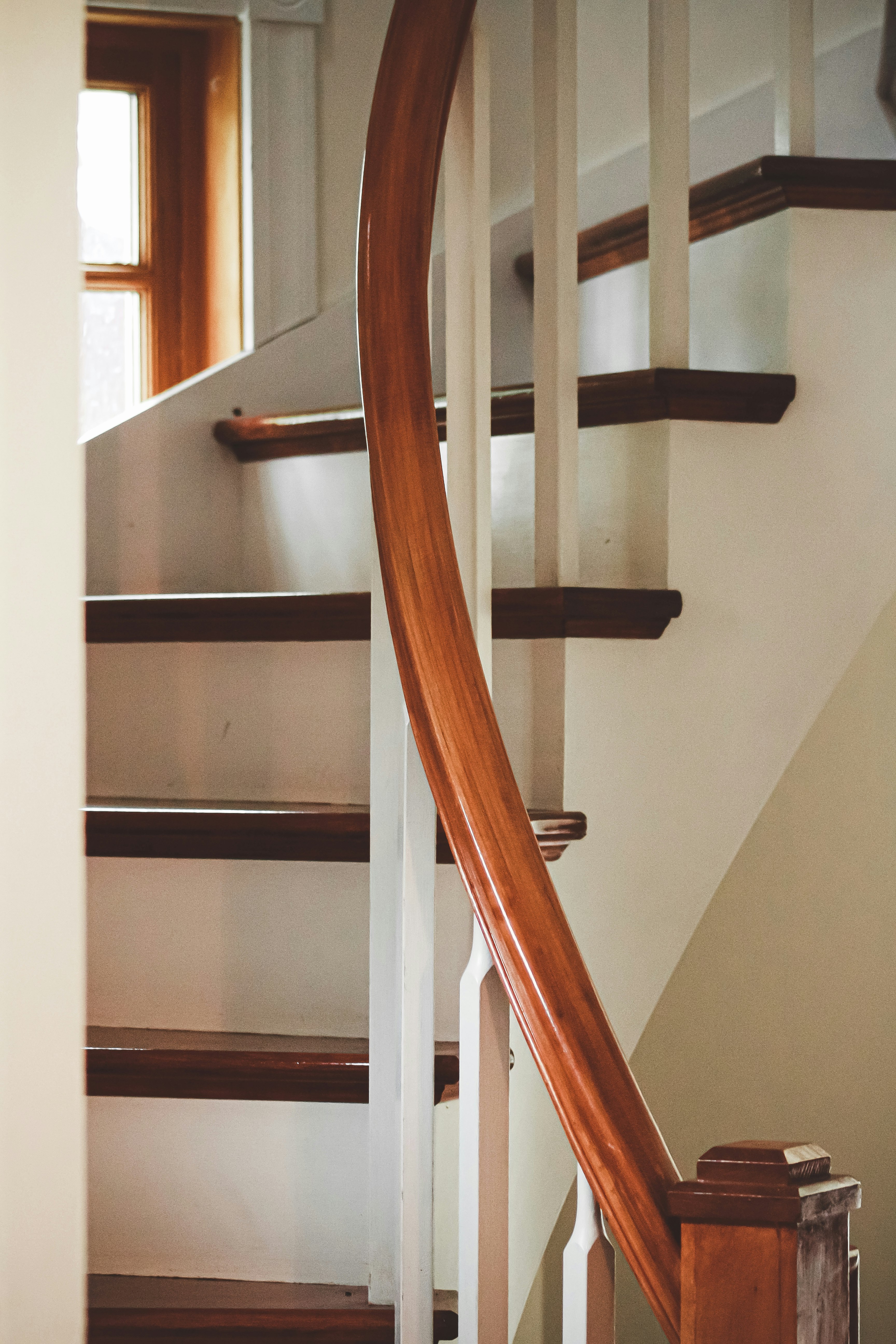 brown wooden staircase with white wall